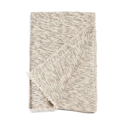 Folded neutral cashmere-merino scarf showing its fine dark flecks and short fringe.