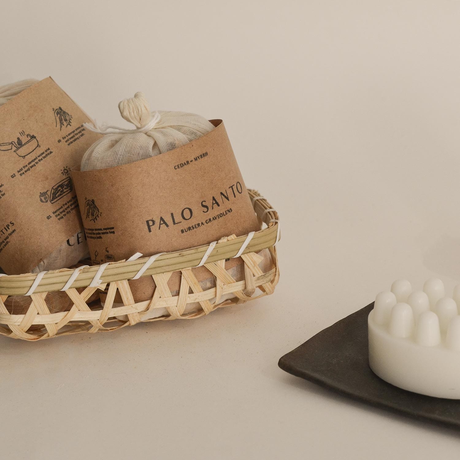 Baskets with Palo Santo incense packaging on a neutral background