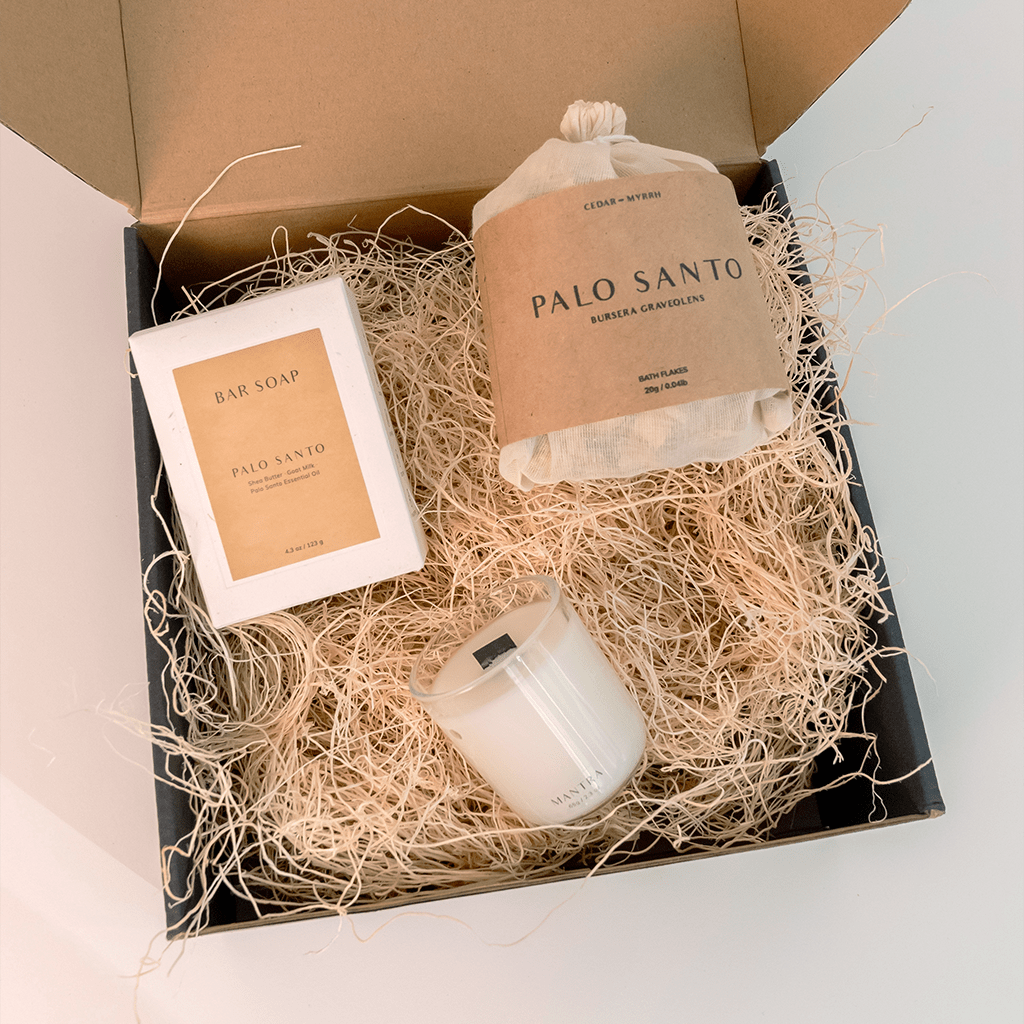 Gift set with Palo Santo products including a candle, soap, and incense bag in a box.