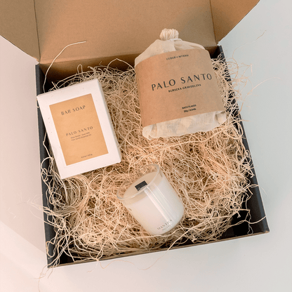 Gift set with Palo Santo products including a candle, soap, and incense bag in a box.