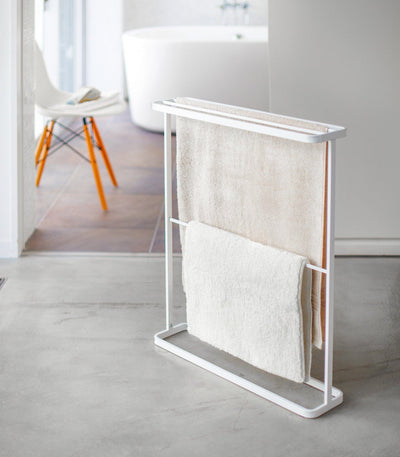 White towel rack with folded towels in a minimalistic bathroom setting. Bath Towel Hanger (30" H)  - Steel