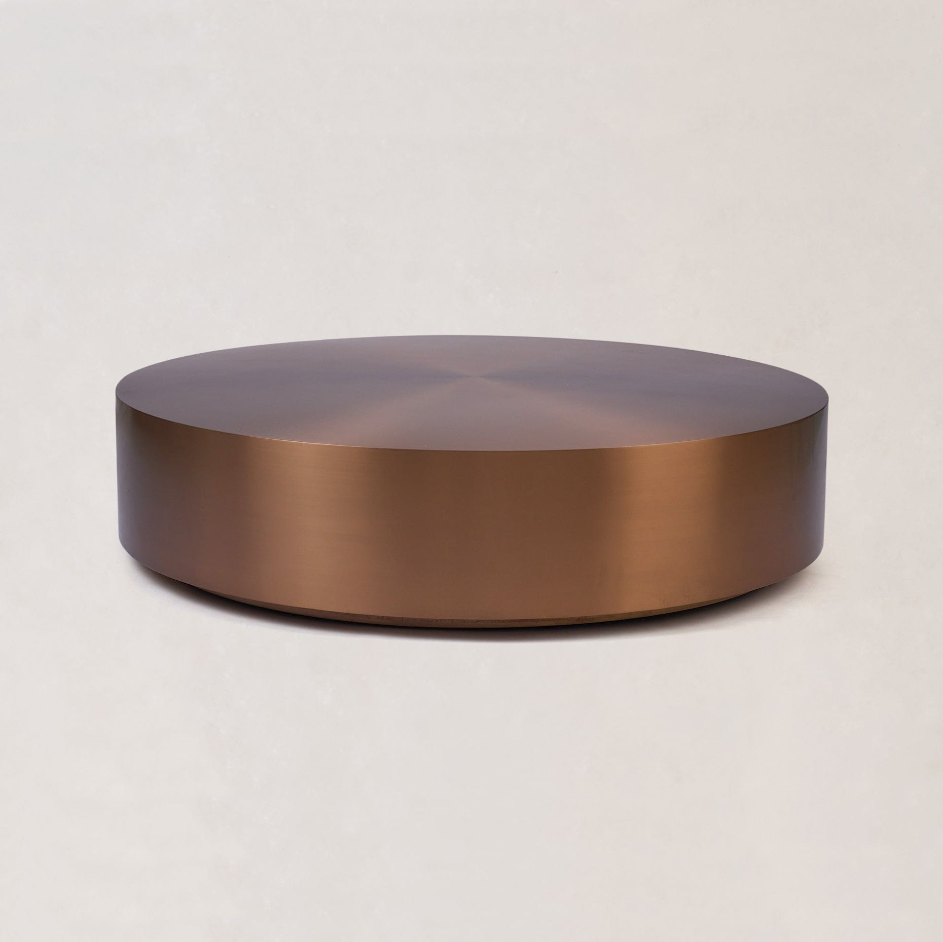 Round copper coffee table with low profile and brushed copper surface