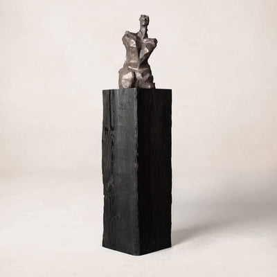 Charcoal sculpture pedestal in shou sugi ban wood, minimalist studio view
