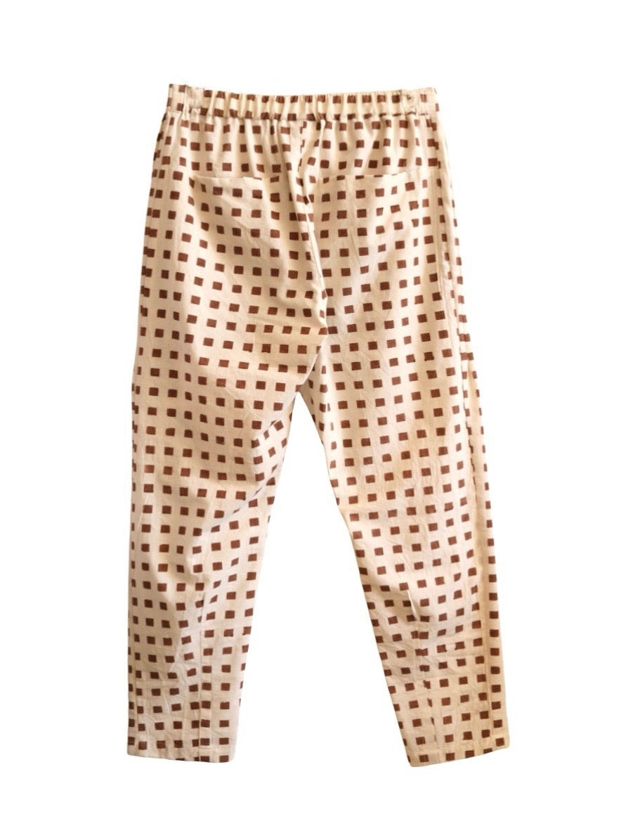 Back product view of cream Souk pants with rust-red squares and an elastic waistband.