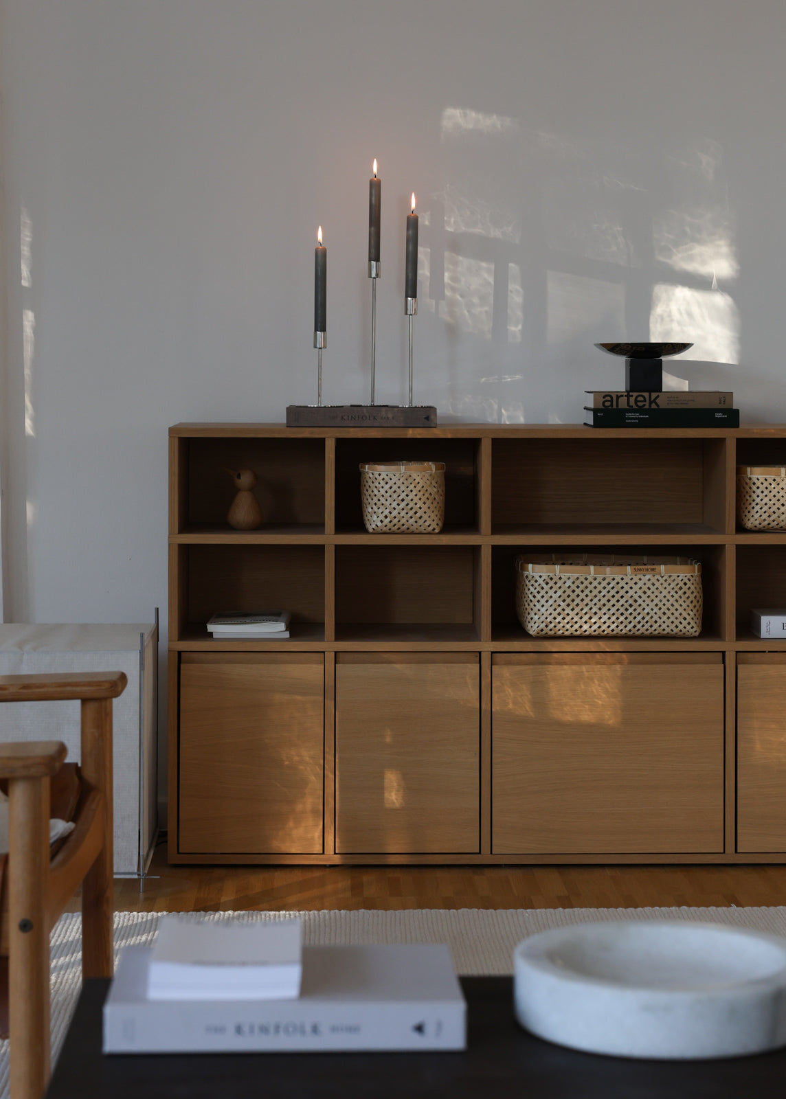 Muko baskets used for concealed and open storage in a sunlit wood sideboard.