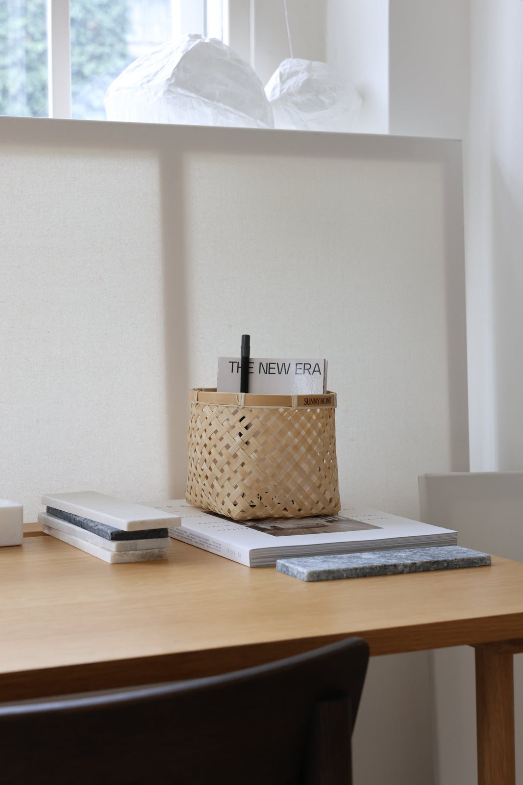 Small bamboo basket used as a desktop organizer for pens and stationery.