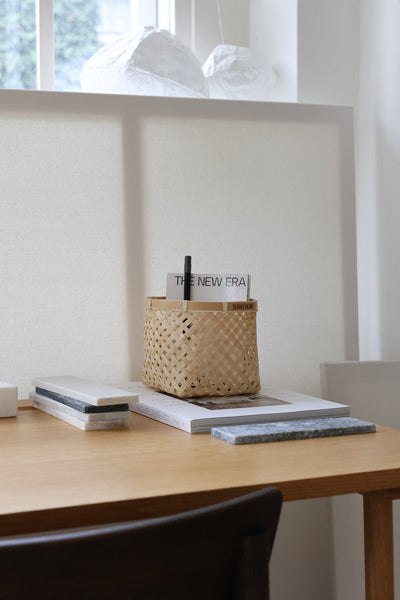 Small bamboo basket used as a desktop organizer for pens and stationery.