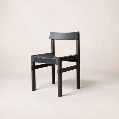 A black dining chair with a full-grain leather seat and wooden frame, inspired by the Torii Gate design, on a plain background.