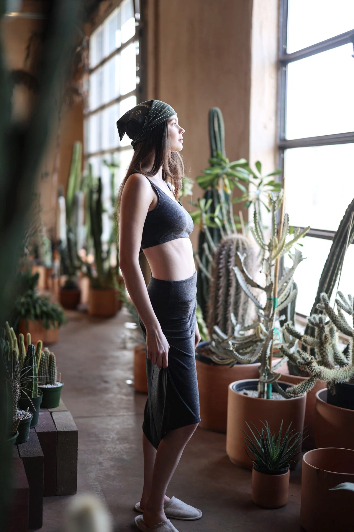 Woman wearing the convertible merino wool dress and skirt in a light-filled interior, showcasing versatile styling and natural wool comfort.