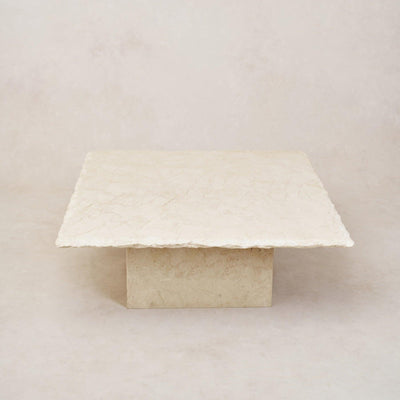 A square-shaped Sofita Marble coffee table with a smooth top surface and a visibly textured edge on a light background.