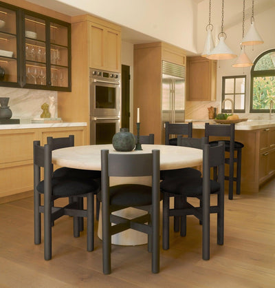 Teddy black dining chairs styled around round dining table in warm kitchen setting