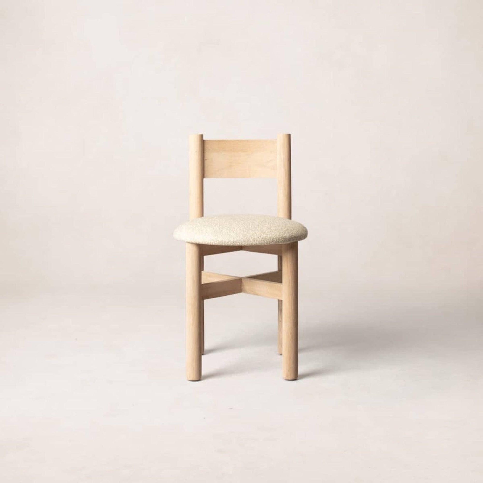 A single Teddy dining chair with a natural wood frame and beige upholstered seat, displayed against a neutral background.