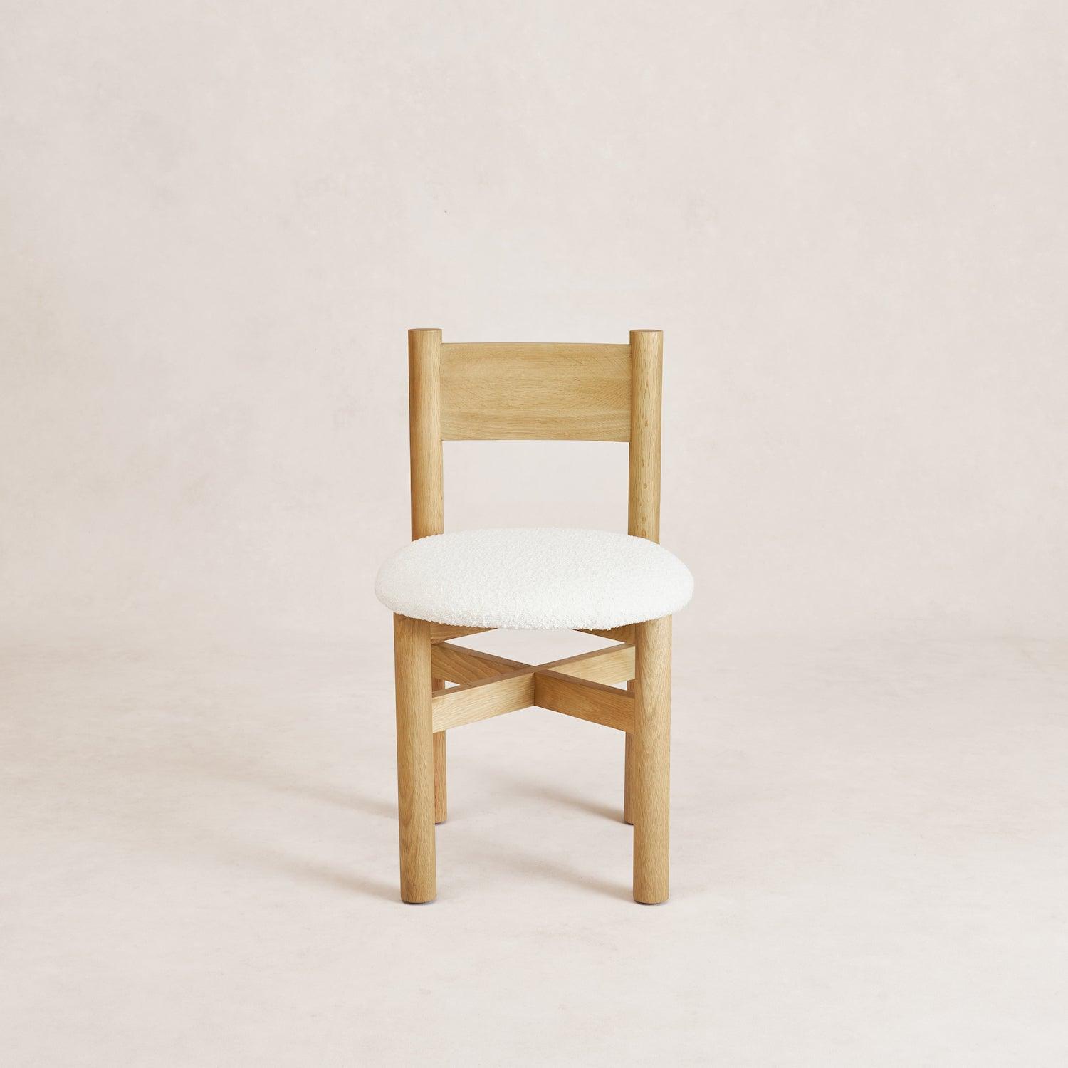 A straight back dining chair with white oak wooden legs and a white boucle upholstered seat. Teddy Dining Chair - White Oak
