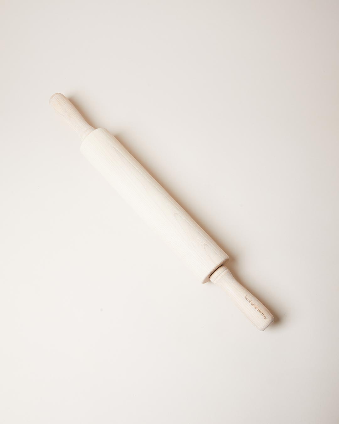 Whitewashed ash rolling pin displayed diagonally against a pale neutral background.