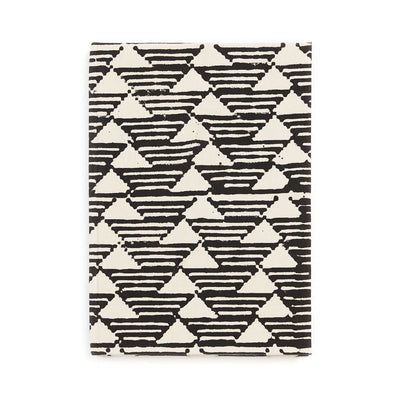 Front view of the Tria journal’s bold black-and-white cover featuring repeating striped triangles