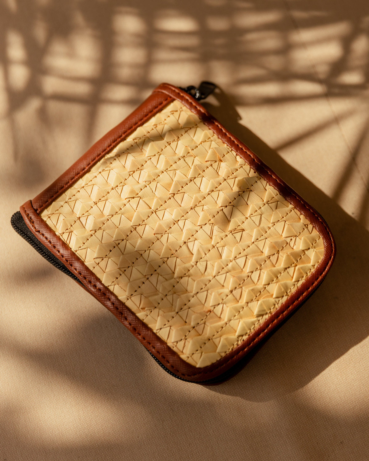 Village Thrive Rattan & Canvas Compact Eco Tote Bag, natural rattan cane with brown trim, close-up angled view.
