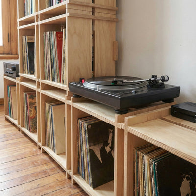 Close-up of Williamsburg Cubical record storage units holding vinyl albums with a black turntable positioned on top