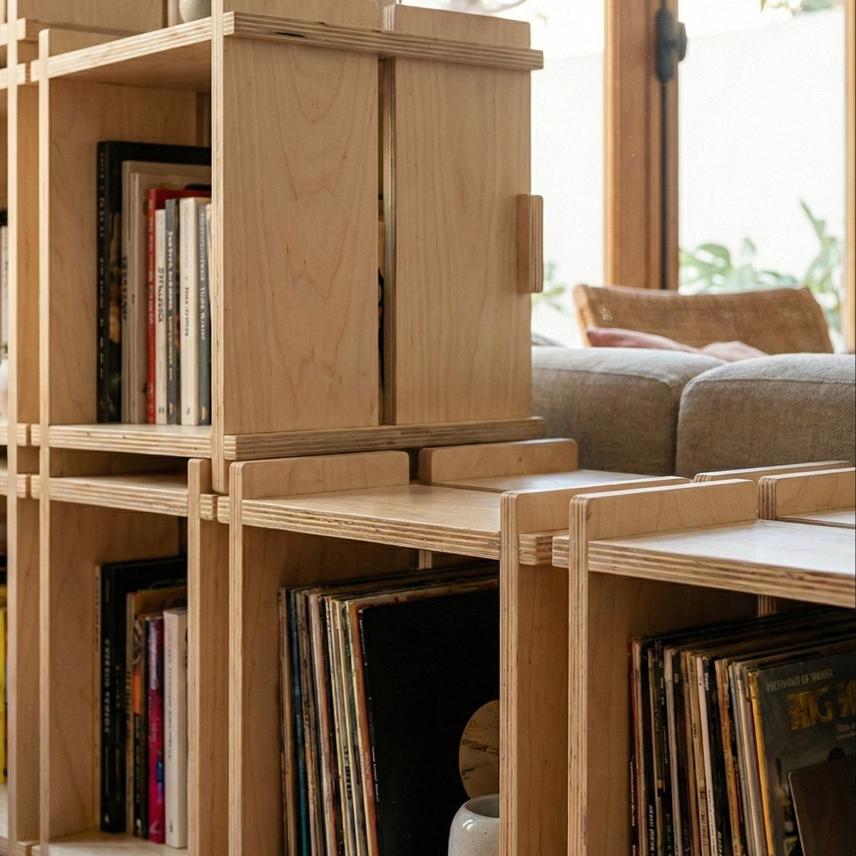 Close-up of stacked Williamsburg Cubical units showing their interlocking wood frames, projecting corner joints, books and vinyl records