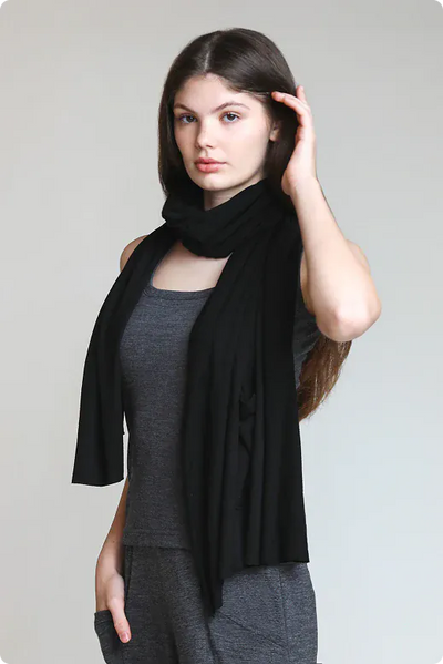 Woman wearing a merino wool pocket wrap as a scarf and shawl, showcasing versatile styling and natural comfort.