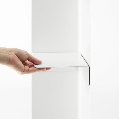 A hand slides the white shelf component of the Yamazaki Home Rolling Bathroom Organizer - Steel into position against the upright panel, showing its folded edges.